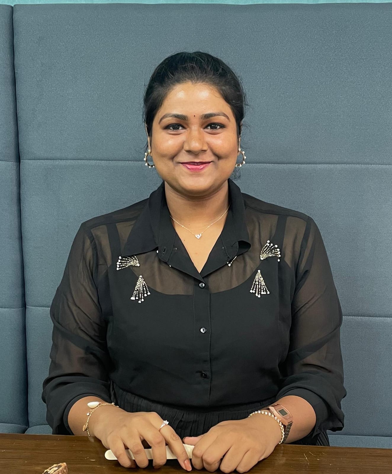 Portrait of the principal smiling warmly in a colorful school hallway with children playing in the background